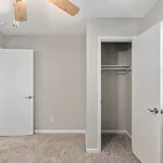 Step into elegance with this bright and airy bedroom, featuring a spacious closet and modern ceiling fan.