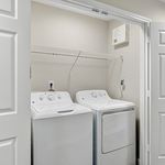 Modern laundry area featuring a sleek washer and dryer set within an accessible closet.