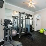 Modern fitness room with sleek exercise equipment, mirrored walls, and vibrant workout gear for a dynamic home workout experience.