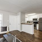 Modern apartment interior with sleek kitchen, inviting open-plan living area, and elegant wooden flooring.