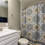 Chic bathroom with a stylish vanity and vibrant patterned shower curtain, offering a modern and inviting touch.