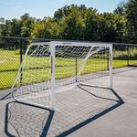 Outdoor sports area with a sturdy soccer goal set against a lush green backdrop, perfect for recreational activities.
