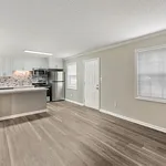 Modern open-concept kitchen with sleek stainless steel appliances, chic backsplash, and elegant hardwood flooring, flooded with natural light.