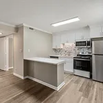 Modern open kitchen with sleek stainless steel appliances, stylish backsplash, and elegant cabinetry, complemented by warm wood flooring.