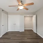 Bright and inviting bedroom with elegant ceiling fan, spacious closets, and stylish hardwood flooring.