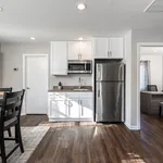 Contemporary kitchen with sleek stainless steel appliances, elegant white cabinetry, and rich wood flooring for a modern touch.
