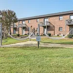 Charming brick apartment complex with cozy balconies and a serene hammock park, perfect for relaxation.