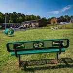 Lush apartment community featuring a vibrant dog park with playful structures and scenic views of residential buildings.
