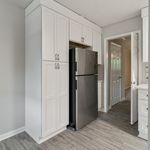 Modern kitchen design with sleek stainless steel refrigerator, elegant white cabinetry, and stylish wood flooring, offering a perfect blend of functionality and aesthetics.