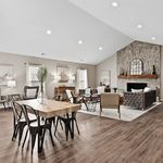 Elegant open-concept living and dining area with stylish decor, cozy fireplace, and modern furnishings, perfect for entertaining.