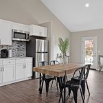 Contemporary kitchen with stainless steel appliances, sleek cabinetry, and a chic dining area with modern decor, perfect for entertaining.