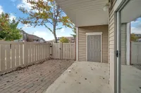 Charming patio space with a privacy fence, ideal for outdoor relaxation in a serene apartment setting.