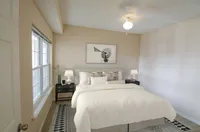 Bright and cozy bedroom featuring elegant decor, soft lighting, and a plush bed inviting restful relaxation.