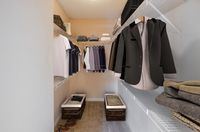 Spacious walk-in closet with organized shelving showcasing elegant clothing and storage baskets for optimal organization and style.