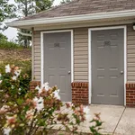 Charming exterior view with dual entrances, enhanced by vibrant greenery in the foreground.