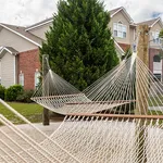 Relaxing communal area with inviting hammocks, lush greenery, and charming brick architecture.