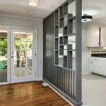 Inviting home interior featuring chic French doors, stylish partition, and a modern kitchen with elegant flooring.