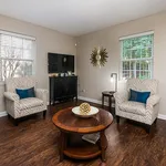 Chic and cozy living room with stylish patterned armchairs, modern decor, and a sleek wall-mounted TV, creating an inviting atmosphere.