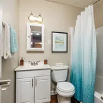 Chic bathroom with modern fixtures, bright vanity, and stylish ombre shower curtain.