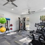Bright and modern fitness room with exercise equipment, vibrant yoga balls, and large windows for natural light.