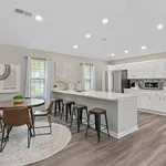 Modern open-concept kitchen and dining area with sleek white cabinets, stainless steel appliances, and elegant wooden flooring.