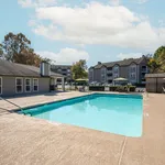 Inviting outdoor pool area with comfortable seating in a peaceful apartment complex, perfect for relaxation and sunny days.