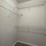 Spacious walk-in closet with sleek white wire shelving for organized storage solutions.