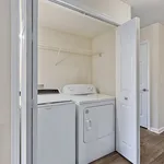 Chic laundry closet with modern washer and dryer, featuring an open shelf for convenient storage.