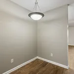 Charming alcove with sleek wood flooring and modern pendant light, offering a cozy space for creative designs.