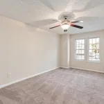 Inviting bedroom with plush carpeting, large windows for natural light, and a modern ceiling fan.