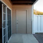 Inviting outdoor patio with elegant sliding glass door and secure entrance, perfect for relaxing and entertaining in style.