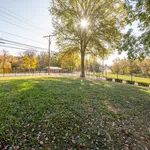 Charming outdoor area with lush green grass, a majestic tree, and serene surroundings ideal for relaxation.