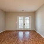 Bright and airy room with elegant wood flooring, inviting natural light through large French doors, perfect for a cozy living space.