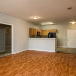 Inviting open-concept living space with elegant wooden floors and a modern kitchen featuring sleek appliances and ample cabinetry.