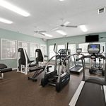 Inviting fitness center equipped with modern exercise machines, natural light, and vibrant ambiance for an energizing workout experience.