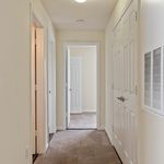Bright and welcoming hallway with soft carpet flooring and elegant white doors, leading to spacious rooms.