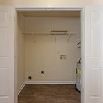 Efficient laundry area with utility hookups and sleek wood flooring, perfect for modern living.