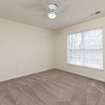 Bright and airy bedroom featuring plush carpeting, a ceiling fan, and large windows inviting natural light.