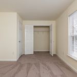 Bright and spacious bedroom with plush carpet, ample closet space, and a large window for natural light.