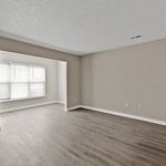 Bright and spacious living room with elegant wood flooring and large windows for natural light.