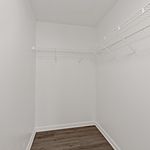 Spacious walk-in closet with sleek white walls and modern wire shelving, perfect for organized storage.