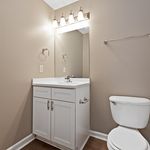 Elegant bathroom with modern lighting, sleek vanity, and classic fixtures in a serene, neutral decor.