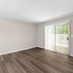 Bright, spacious living area with sleek hardwood flooring and large sliding glass doors opening to private outdoor space.