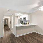 Modern apartment kitchen with sleek countertops, stylish backsplash, and elegant wood flooring.