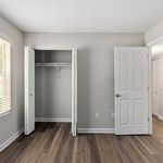 Bright and spacious bedroom with elegant hardwood floors and ample closet space in a modern apartment.