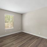 Bright, airy room with sleek wood flooring and a large window allowing natural light to flood in.