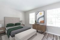 Spacious room with elegant dark wood flooring and soft neutral walls, enhanced by a ceiling fan for comfort.