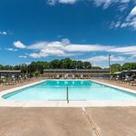 Inviting outdoor swimming pool with lounge chairs and a clear blue sky, perfect for relaxation and enjoyment.