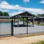 Inviting outdoor grilling area with a covered pavilion, perfect for gatherings and relaxation under a clear blue sky.
