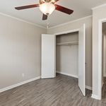 Inviting bedroom with modern gray flooring, spacious closet, and elegant ceiling fan, perfect for a cozy retreat.